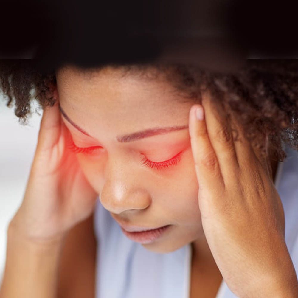 Woman with red eyes holding her head